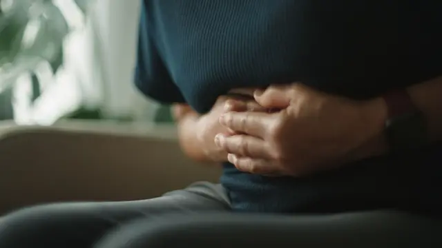 Karnını tutan bir kadın Karnını tutan bir kadın
